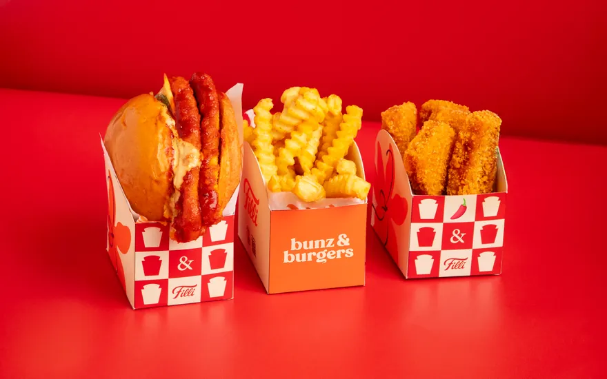 FiLLi Korean Burger with crinkle fries and Korean chicken nuggets on a red table