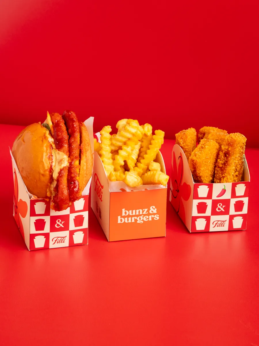 FiLLi Korean Burger with crinkle fries and Korean chicken nuggets on a red table